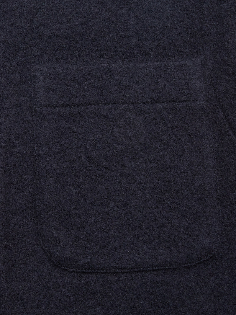 Close-up of the Koi Wool Gilet in Navy by Blue de Gênes, showing dark textured boiled wool and a large patch pocket—typical features of an insulating vest.