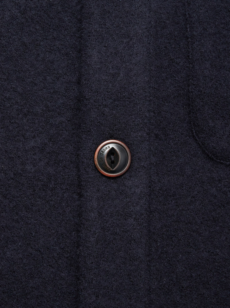 Close-up of the Blue de Gênes Koi Wool Gilet in navy, featuring a single round button sewn with black thread and showcasing the soft, textured wool fabric.