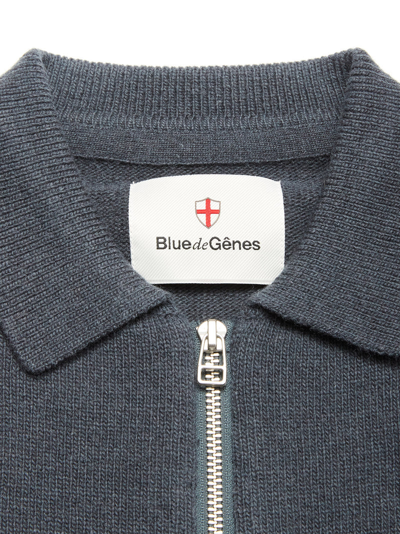 Close-up of the Nuvali Polo Cardigan in Dark Slate—a textured men's zip-up cardigan with collar. The inside label displays Blue de Gênes and a red and white shield logo.