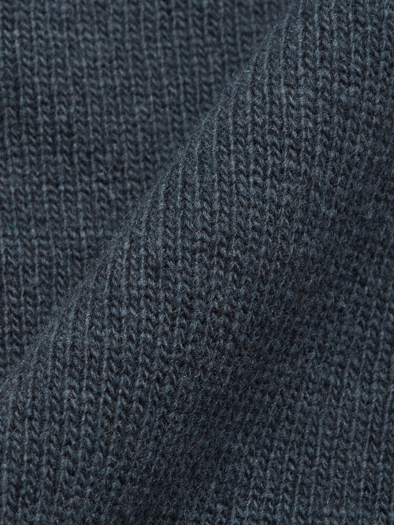 Close-up of Blue de Gênes Nuvali Polo Cardigan - Dark Slate, showcasing detailed knit texture. The fabric’s soft, flexible wool blend is highlighted by gentle folds.