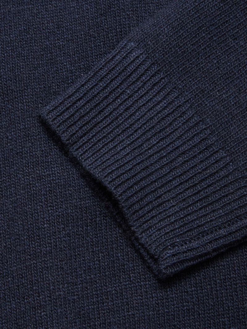 Close-up of the Nuvali Polo Cardigan - Navy by Blue de Gênes, highlighting the ribbed wool blend sleeve with its detailed knit texture and cuff.