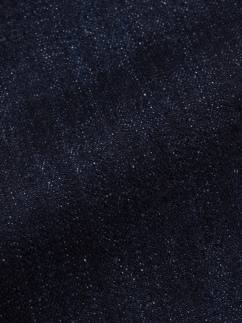 Close-up of Vinci Girisha Rinse Jeans by Blue de Gênes, highlighting the dark blue stretch denim’s textured weave and subtle white specks—a signature of quality five-pocket jeans.