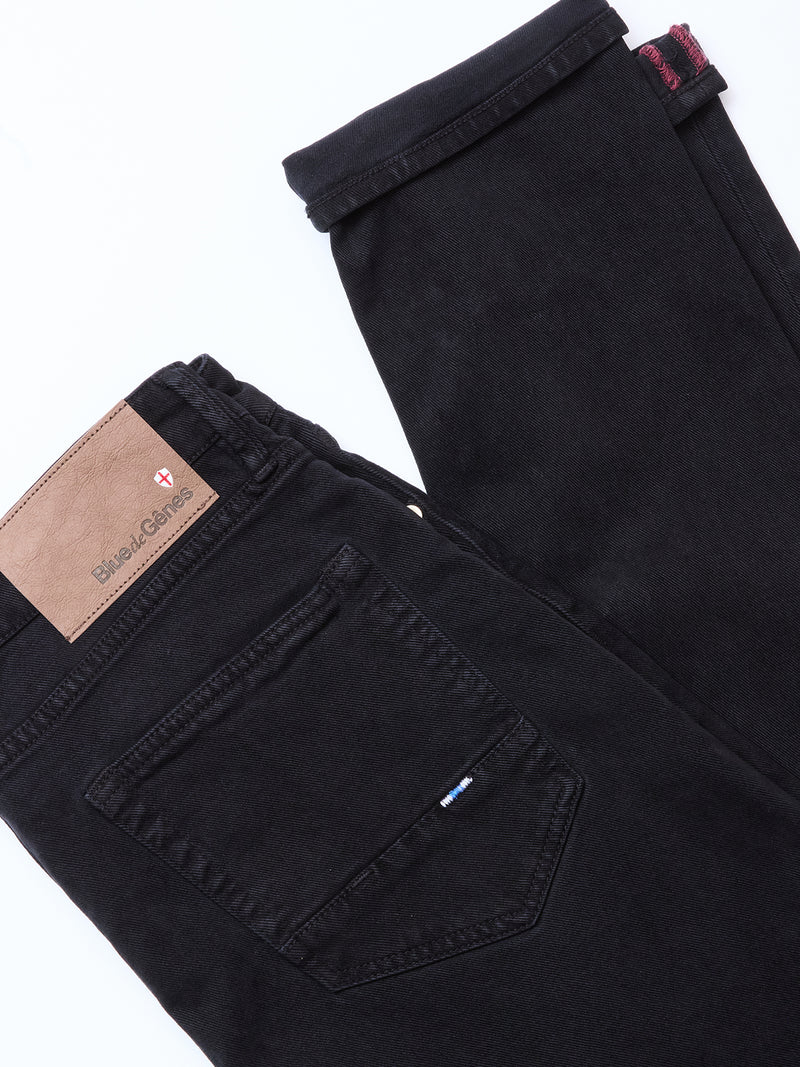 A neatly folded pair of Blue de Gênes Vinci Iro Pant in navy, regular fit with comfort stretch twill, featuring a visible brown leather patch on the waistband and a back pocket with a small blue and white tag.