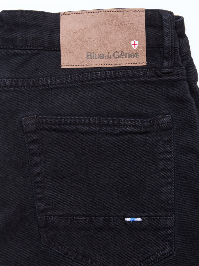 Close-up of the back pocket and waistband of Blue de Gênes Vinci Iro Pant in navy, regular fit with comfort stretch twill, featuring a brown leather brand patch and small stitched flag detail near the pocket.