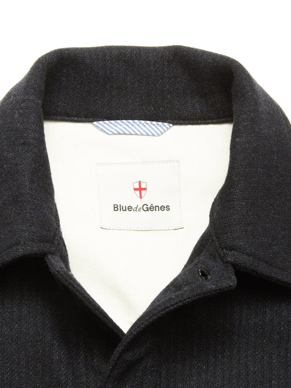 Close-up of the Vincenzo Solid Jacket - Dark Navy by Blue de Gênes. The label displays the brand with a red and white shield logo, while the white inner lining features a blue-striped neck tag.