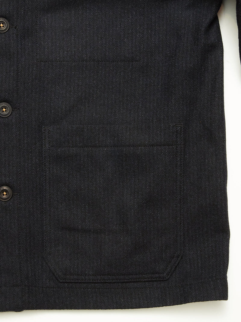 Close-up of the Blue de Gênes Vincenzo Solid Jacket - Dark Navy, highlighting a large front pocket with visible stitching and button closure. Italian wool, relaxed fit, and subtle vertical pinstripes in dark navy fabric.