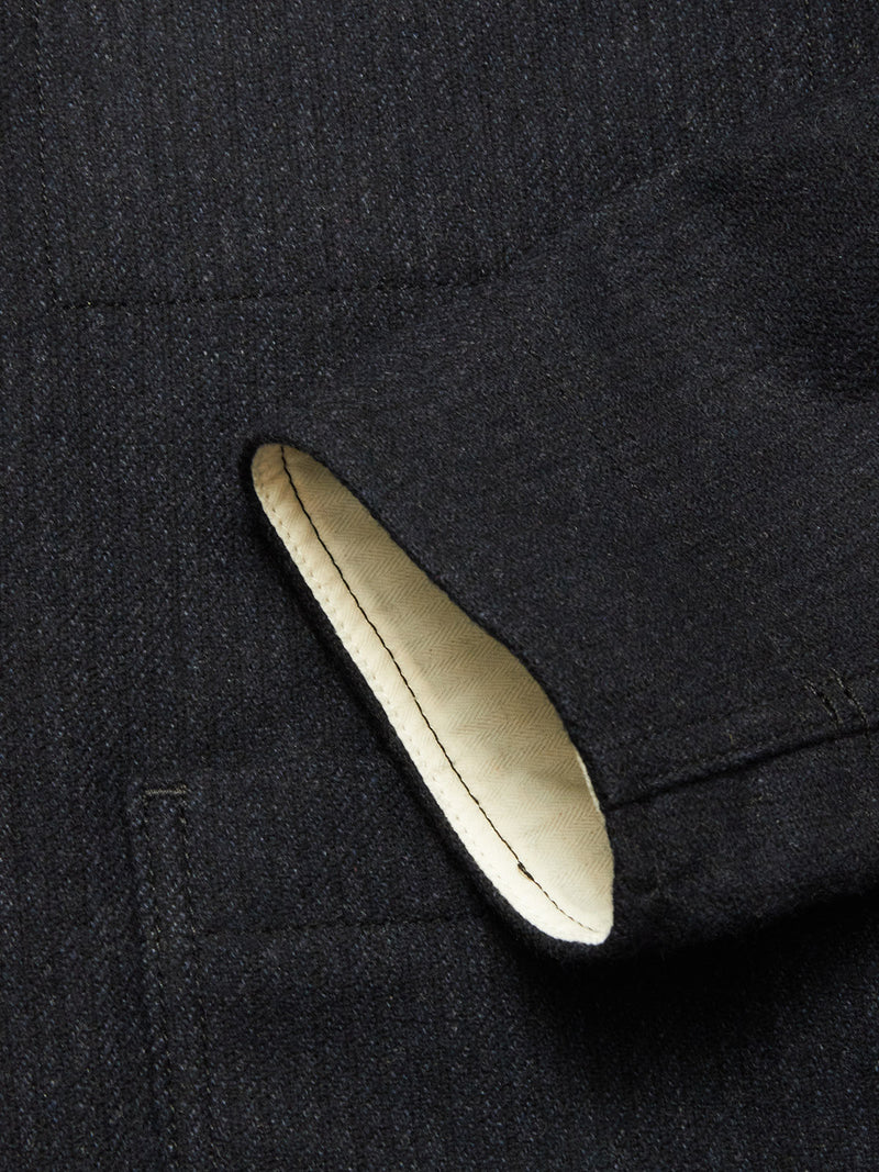 Close-up of the Vincenzo Solid Jacket in Dark Navy by Blue de Gênes, featuring a welt pocket and a glimpse of the light inner lining at the pocket opening.