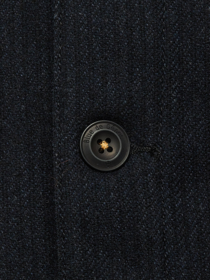Close-up of the Vincenzo Solid Jacket - Dark Navy by Blue de Gênes, featuring a black engraved button. This relaxed fit coat is expertly crafted from a premium Italian wool blend.