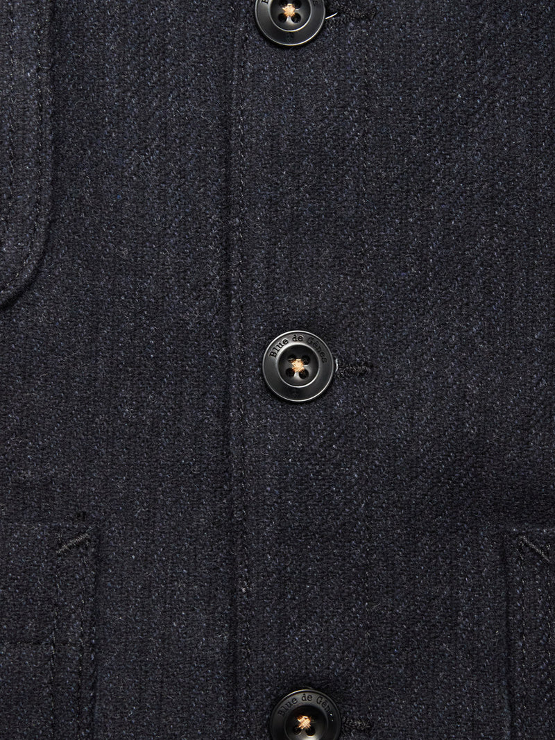 Close-up of the Maurice Solid Gilet - Dark Navy by Blue de Gênes, crafted from a dark blue Italian wool blend with black buttons and visible stitching—an elegant, tailored layering piece.