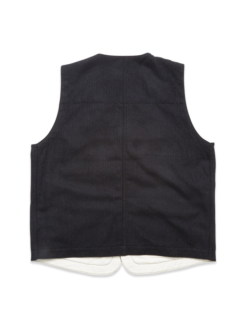 The Maurice Solid Gilet - Dark Navy by Blue de Gênes is shown from the back, highlighting its simple design with no visible buttons or pockets and a slightly curved white lining at the hem—an ideal tailored layering piece.