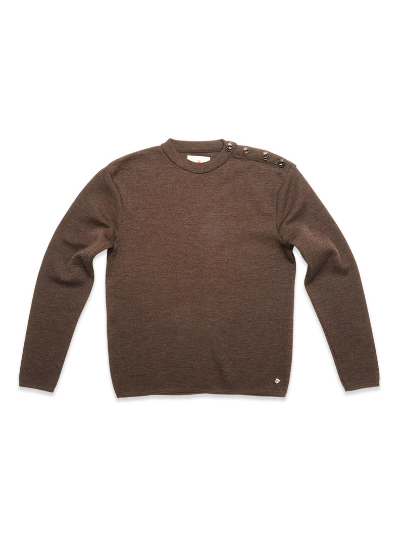 The Blue de Gênes Toyama Knit L/S in brown, a Merino wool crewneck sweater with long sleeves and button detailing on one shoulder, is shown laid flat on a white background.