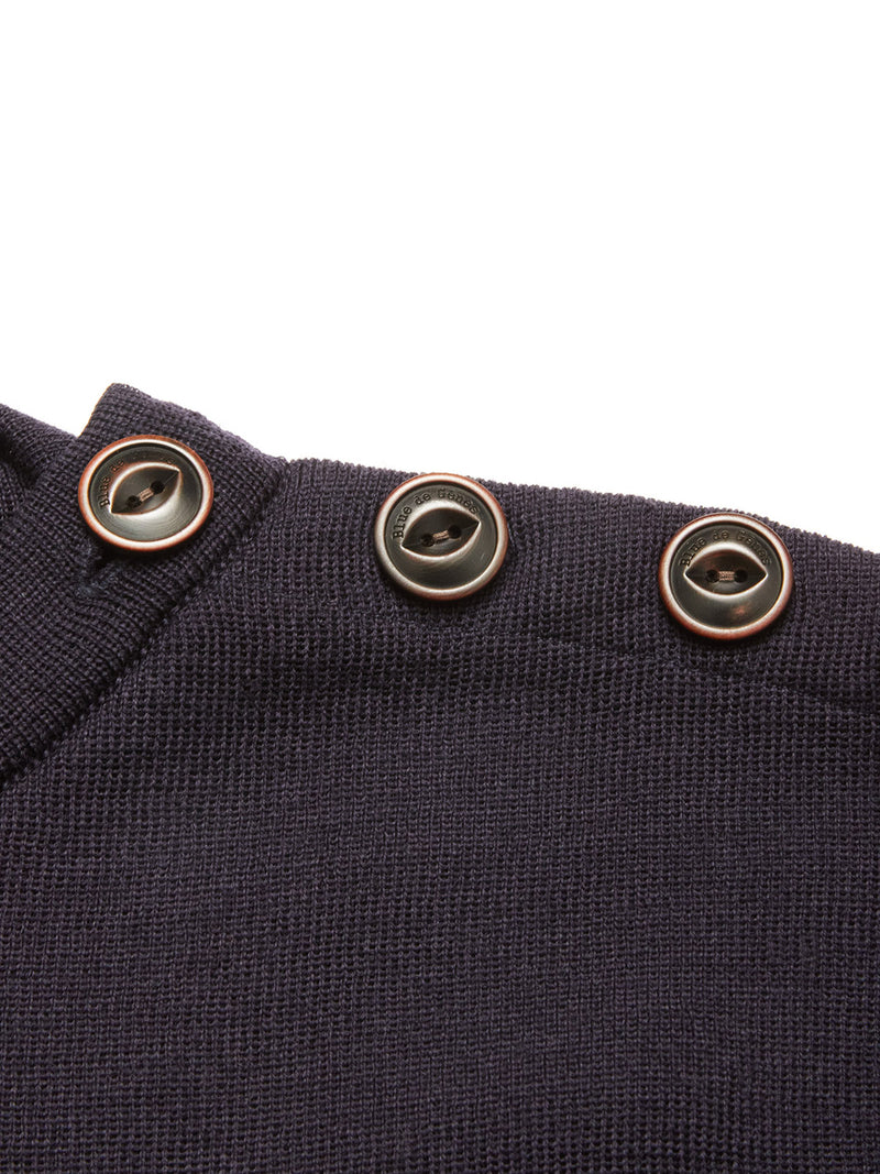 Close-up of the Blue de Gênes Toyama Knit L/S sweater in dark navy Merino wool, featuring three black buttons with metallic rims on the shoulder seam, set against a white background.