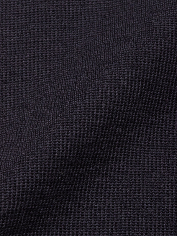 Close-up of the Blue de Gênes Toyama Knit L/S in Dark Navy reveals its textured waffle weave, creating subtle shadows and depth—ideal for a men’s lightweight sweater.