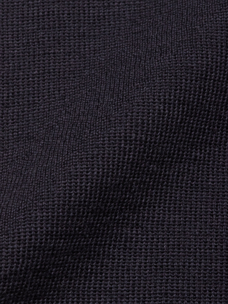 Close-up of the Blue de Gênes Toyama Knit L/S in Dark Navy reveals its textured waffle weave, creating subtle shadows and depth—ideal for a men’s lightweight sweater.