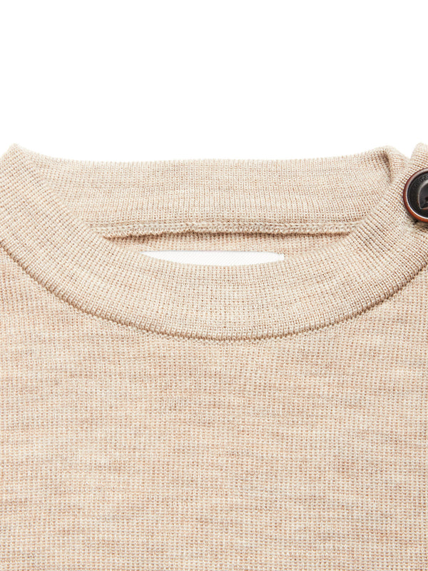 Close-up of the Blue de Gênes Toyama Knit L/S in oat, a beige Merino wool crewneck sweater with a ribbed neckline and brown button detail on the right shoulder.
