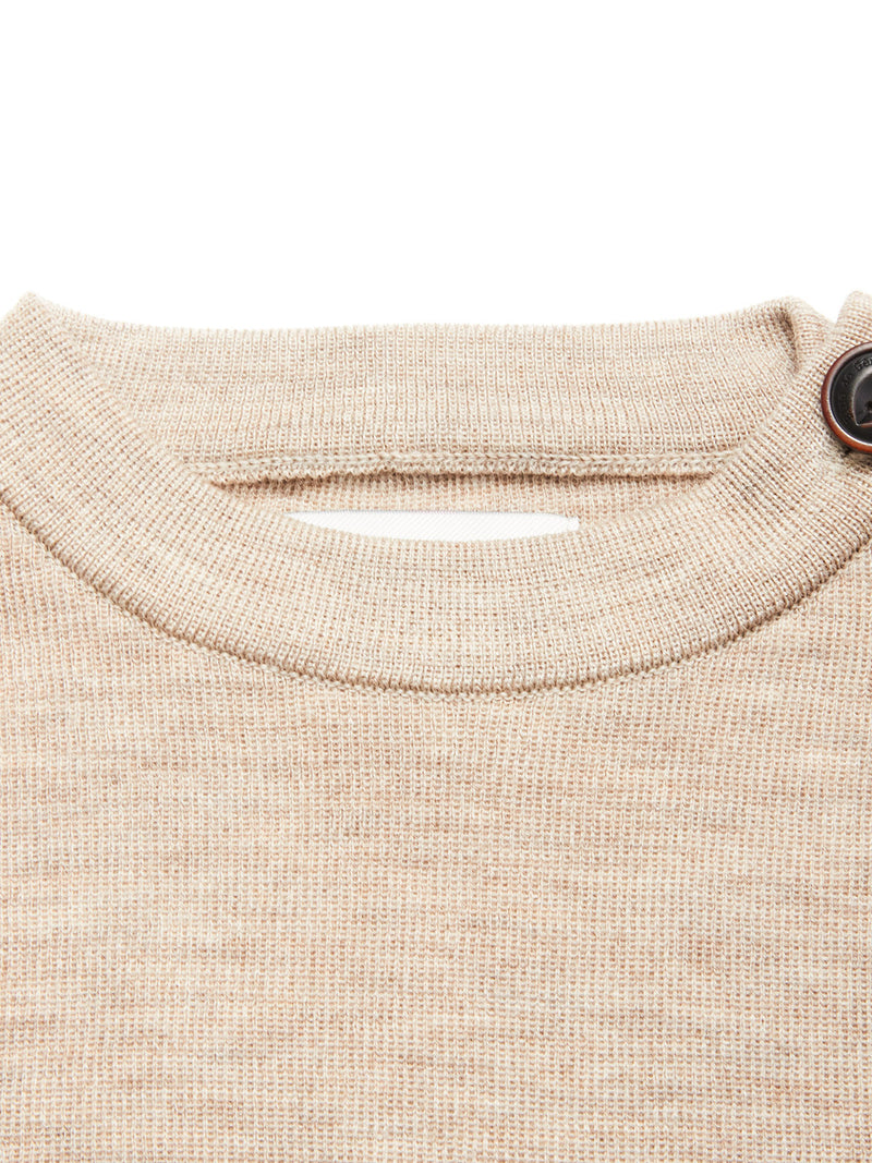 Close-up of the Blue de Gênes Toyama Knit L/S in oat, a beige Merino wool crewneck sweater with a ribbed neckline and brown button detail on the right shoulder.