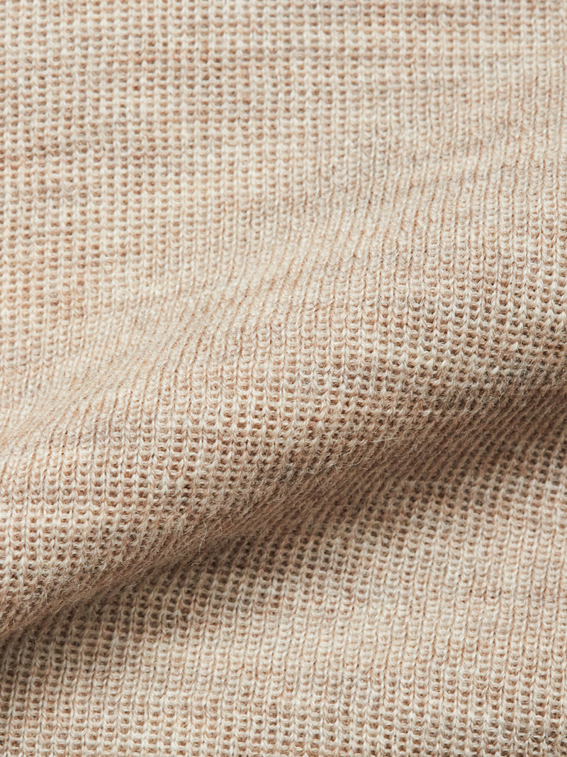 Close-up of the Blue de Gênes Toyama Knit L/S - Oat, showcasing its beige ribbed texture with fine horizontal lines and a soft, cozy look.