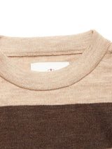 Close-up of the Blue de Gênes Toyama Stripe Knit L/S - Oat, showing a ribbed beige crewneck collar, horizontal brown stripe underneath, and a partially visible white tag with red detail inside the collar.