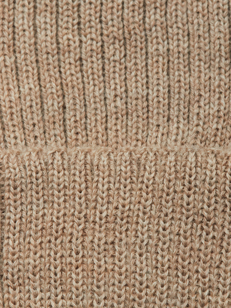 Close-up of the Blue de Gênes Boshi Beanie - Oat, highlighting its beige ribbed knit texture and a horizontal seam across the middle, reminiscent of classic Merino Wool beanies.
