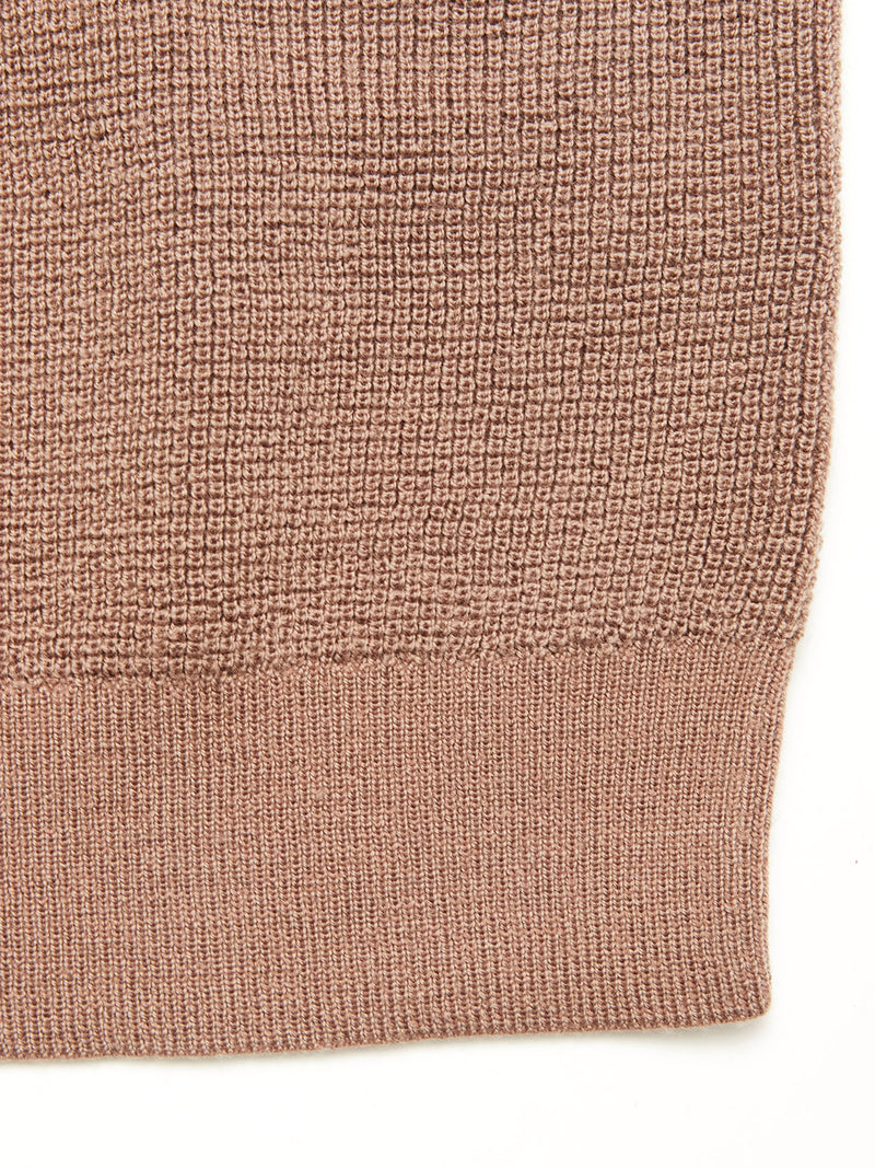 Close-up of the Porto Polo Knit - Fungi by Blue de Gênes, featuring a textured light brown fabric with a visible knit pattern and ribbed hem, creating a subtle grid look that defines casual elegance.