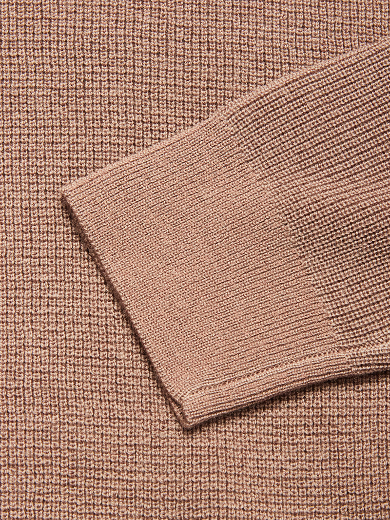 Close-up of the Porto Polo Knit - Fungi fabric by Blue de Gênes, featuring a sweater sleeve over textured light brown knit, highlighting the casual elegance and detailed pattern of this wool polo shirt material.
