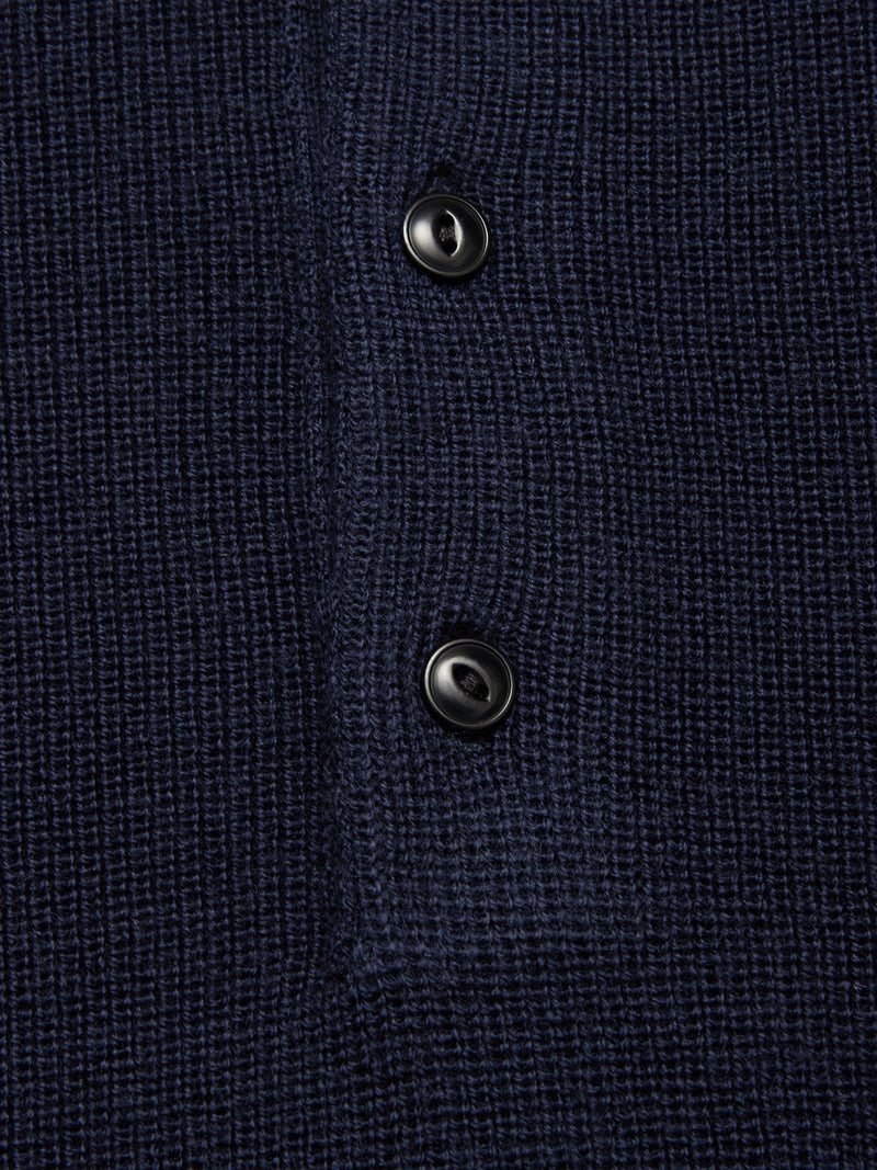 Close-up of the Blue de Gênes Porto Polo Knit in Navy, showcasing its waffle-knit texture and two vertically sewn black buttons on the placket for a touch of casual elegance.