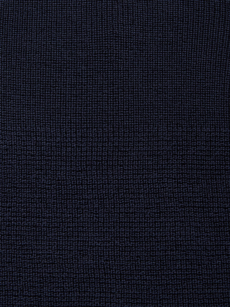 Close-up of Blue de Gênes’ Porto Polo Knit - Navy, featuring a soft, textured fabric with a grid-like woven pattern and subtle checkerboard effect for casual elegance.