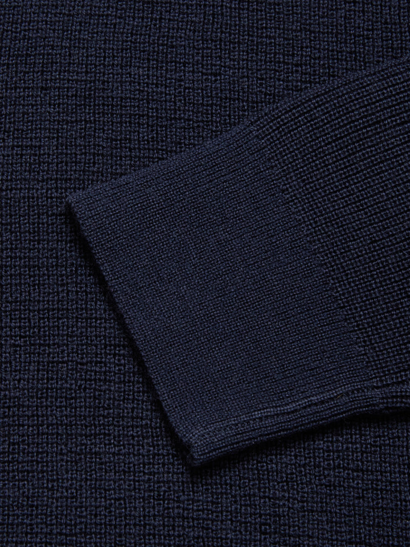 Close-up of the Porto Polo Knit - Navy by Blue de Gênes, featuring its deep navy knit fabric with a visible sleeve edge that highlights the refined texture and understated elegance.