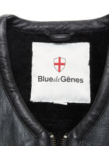 Close-up of the Saga Shearling Gilet - Scarab’s collar and inner lining, featuring a white label with a red shield and cross, Blue de Gênes branding, and traces of German Merino sheepskin for added luxury.