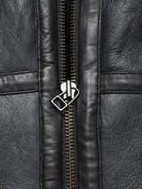 Close-up of the Saga Shearling Gilet - Scarab by Blue de Gênes, showing textured black leather, detailed stitching, and a silver zipper, expertly crafted from premium German Merino sheepskin.