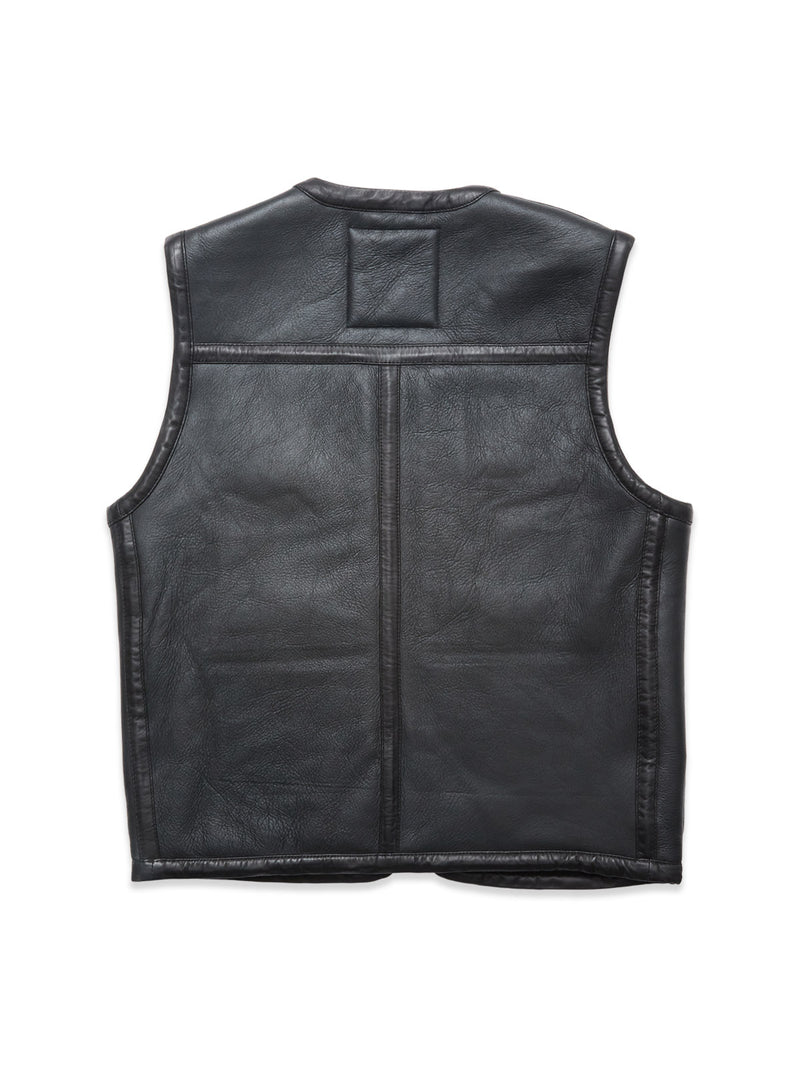 The Blue de Gênes Saga Shearling Gilet - Scarab is a black leather vest photographed from the back, showcasing visible stitching and a rectangular patch near the collar against a white background.