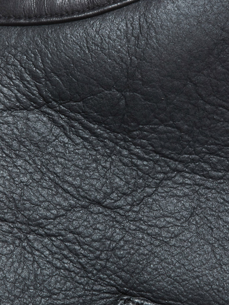 Close-up of black German Merino sheepskin leather on the Blue de Gênes Saga Shearling Gilet - Scarab, highlighting natural wrinkles, creases, glossy finish, and grain patterns—ideal for its reversible shearling design.