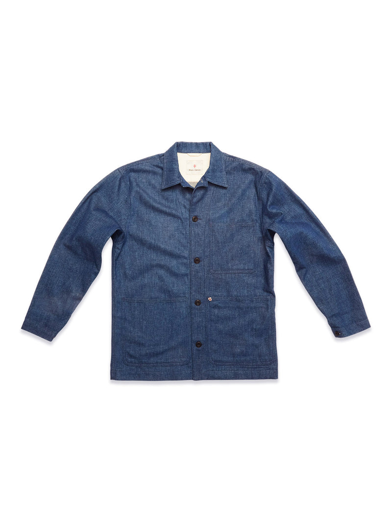 The Yuma Fano Jacket in Denim Blue by Blue de Gênes is a workwear-inspired heavy cotton blend piece with long sleeves, a collar, button-down front, and patch pockets, shown laid flat on a white background.