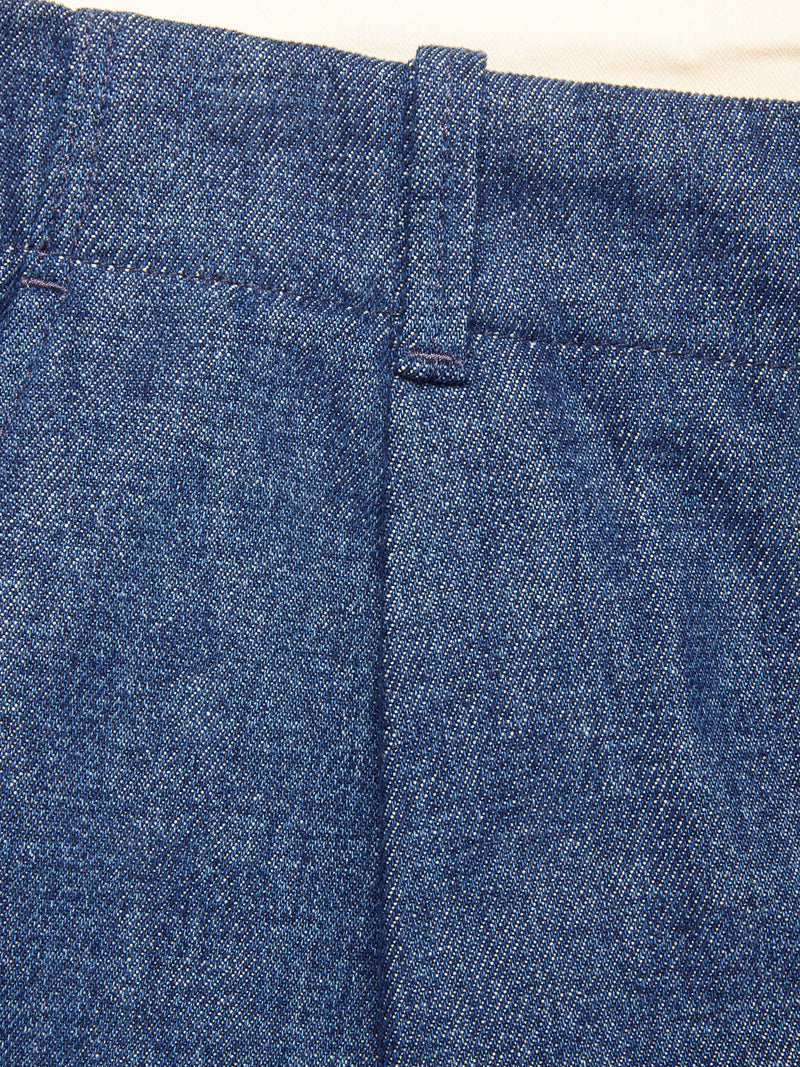 Close-up of the waistband and upper section of blue denim jeans, highlighting a belt loop and stitching details, resembling the durable finish seen on Blue de Gênes' Shogun Fano Pant - Denim Blue.