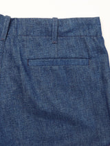 Close-up of Blue de Gênes Shogun Fano Pant in Denim Blue, featuring a relaxed fit chino style, heavy cotton blend fabric, single welt pocket, and belt loops on the waistband, shown against a white background.