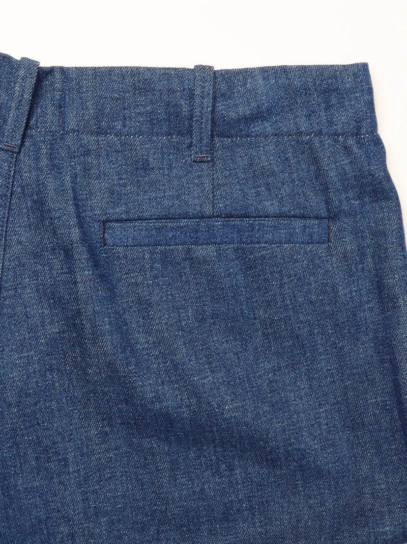 Close-up of Blue de Gênes Shogun Fano Pant in Denim Blue, featuring a relaxed fit chino style, heavy cotton blend fabric, single welt pocket, and belt loops on the waistband, shown against a white background.