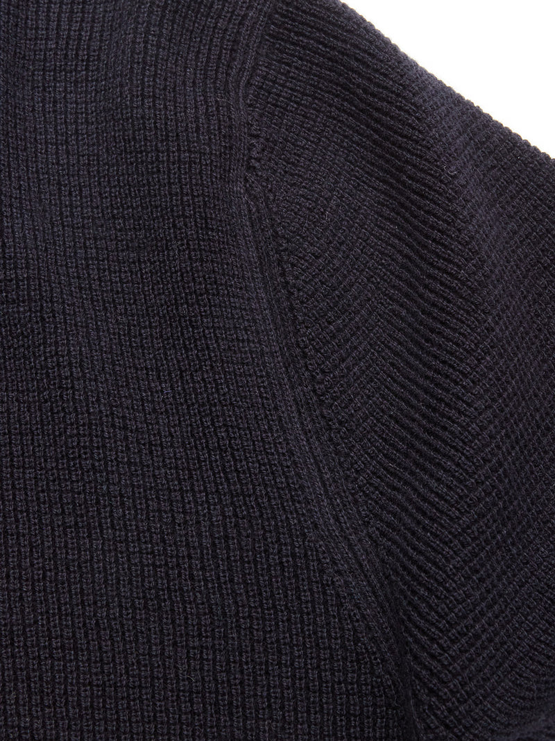 Close-up of the Otia L/S Polo Knit in Navy by Blue de Gênes, highlighting the detailed ribbed texture and stitching on the sleeve or seam.