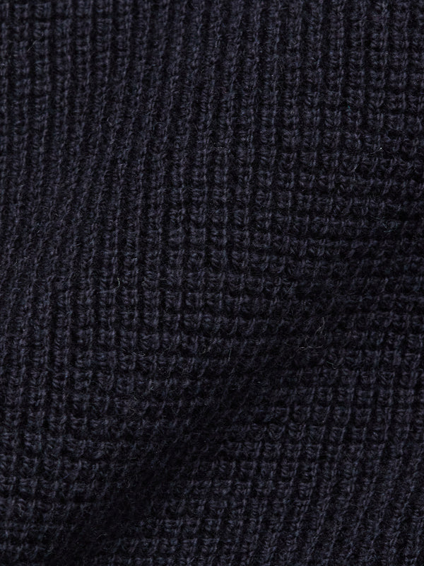 Close-up of the Otia L/S Polo Knit in Navy by Blue de Gênes, featuring a dark ribbed texture—ideal for a luxury long-sleeved knit polo shirt.