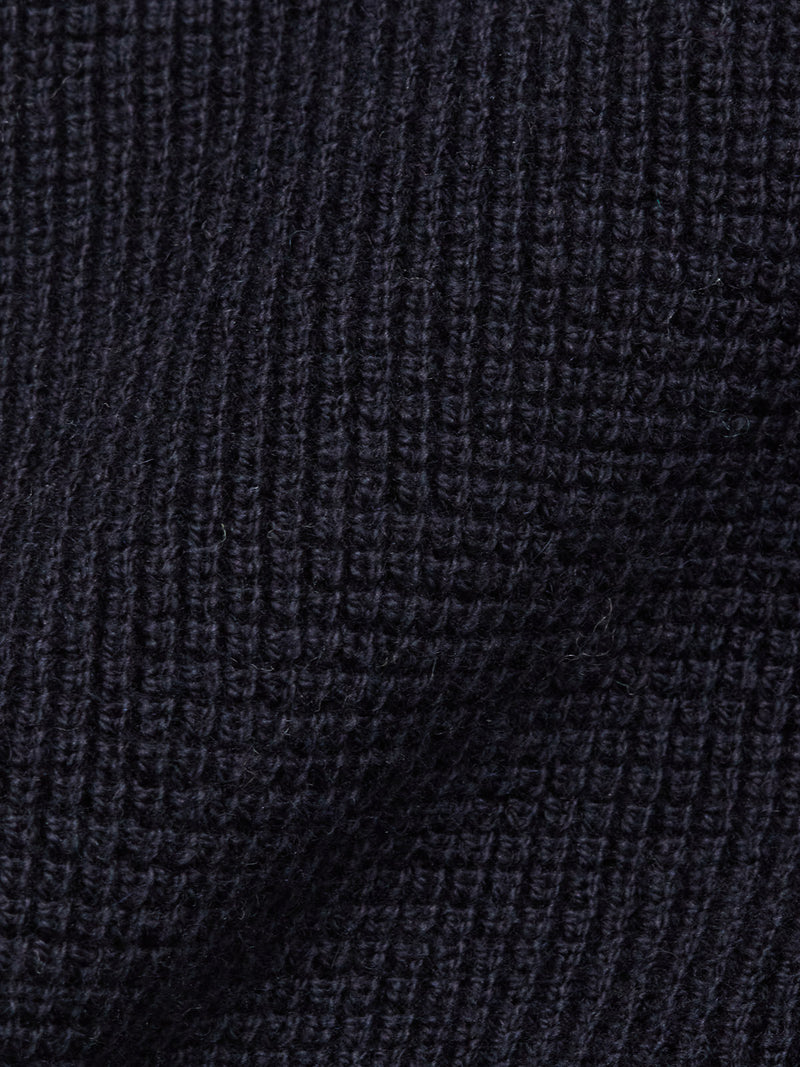 Close-up of the Otia L/S Polo Knit in Navy by Blue de Gênes, featuring a dark ribbed texture—ideal for a luxury long-sleeved knit polo shirt.