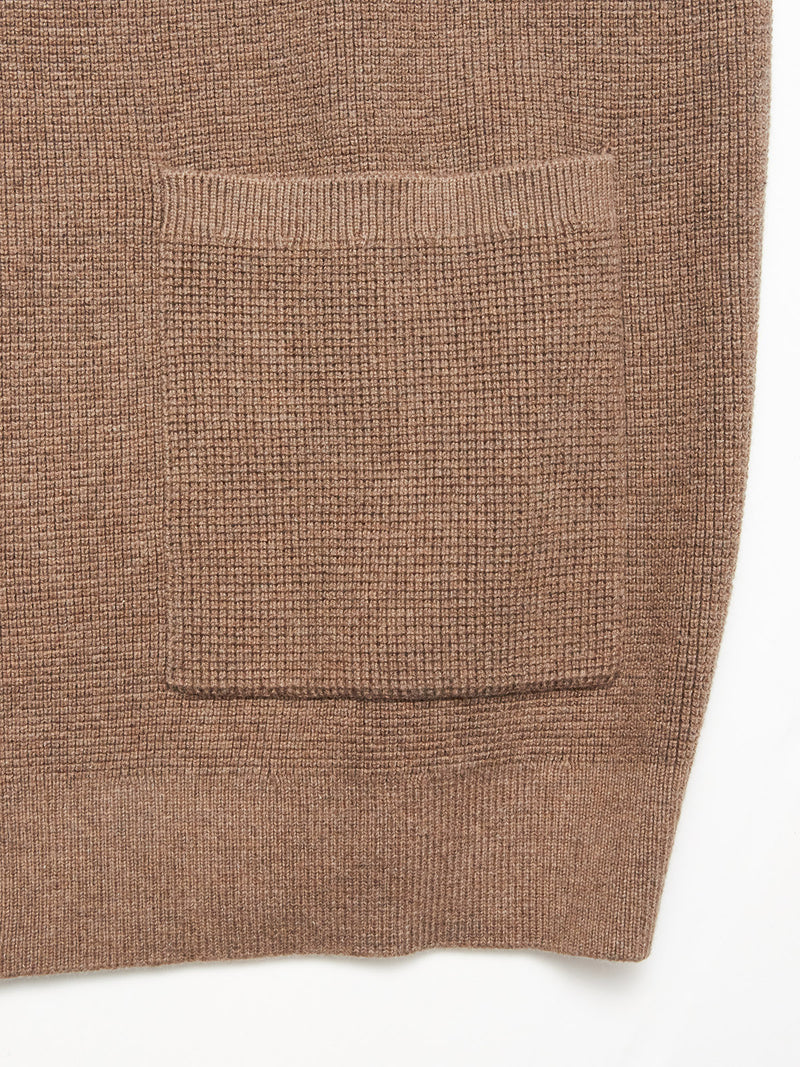 Close-up of the Gifu Knit Cardigan - Chocolate by Blue de Gênes, featuring a brown wool blend, large rectangular pocket, ribbed texture, and simple lines—an elegant classic from the Gifu Knit Cardigan collection.
