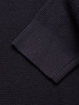 Close-up of the Blue de Gênes Gifu Knit Cardigan in navy, highlighting its fine ribbed and grid-like weave with a folded sleeve overlapping the main body.