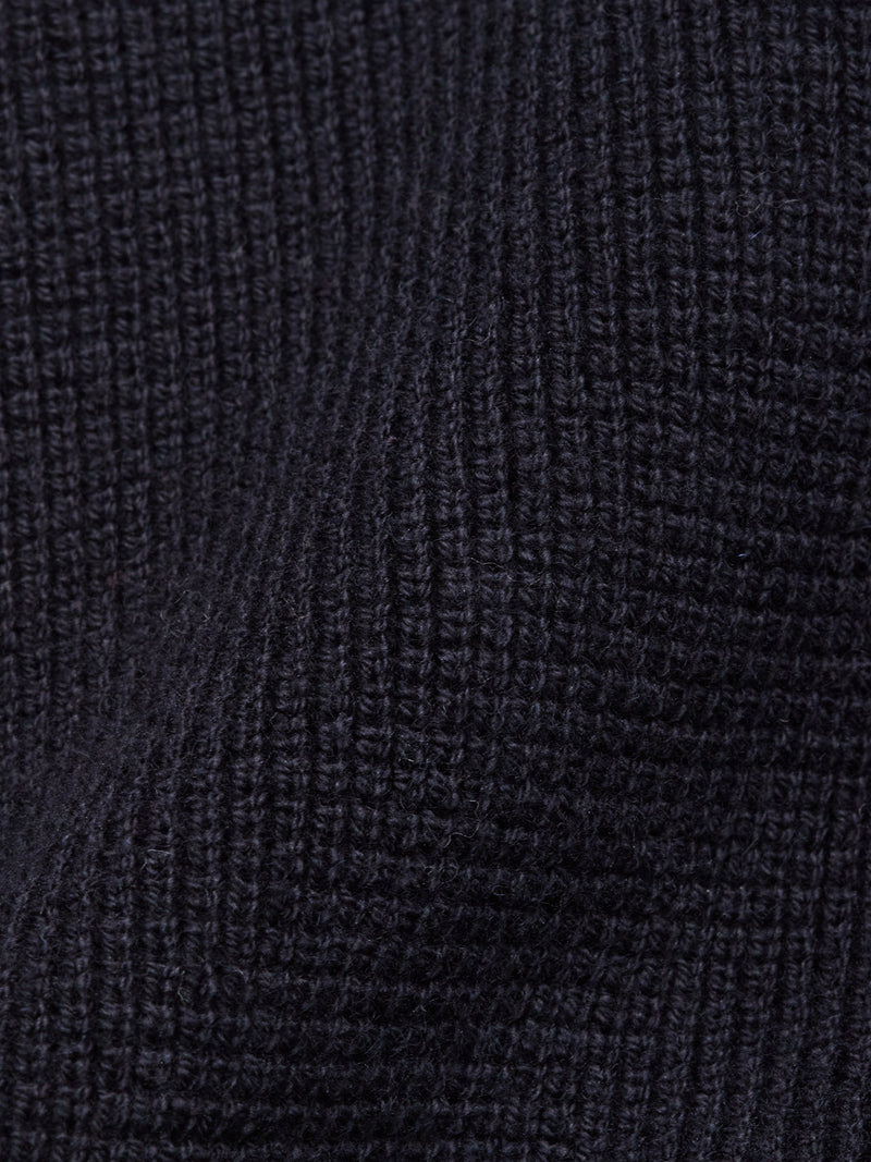 Close-up of the Blue de Gênes Gifu Knit Cardigan - Navy shows a dark, textured fabric with a grid-like ribbed pattern made of fine vertical and horizontal lines and subtle shadows.