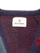 A close-up of a Blue de Gênes label with a red and white shield logo, sewn onto the textured Block Knit Cardigan - Navy Pattern.