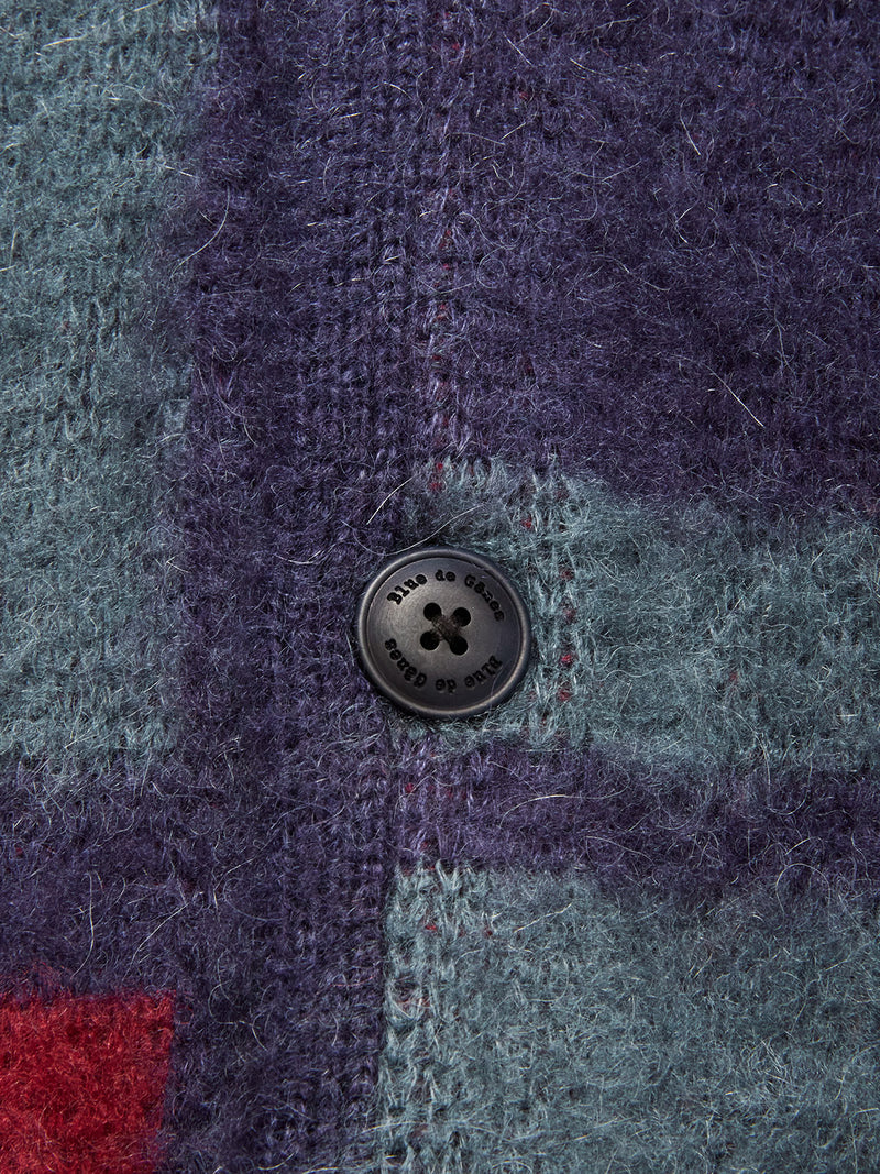 Close-up of the Blue de Gênes Block Knit Cardigan - Navy Pattern, showing its fuzzy multi-color block knit fabric and a black engraved button—ideal for cozy style.
