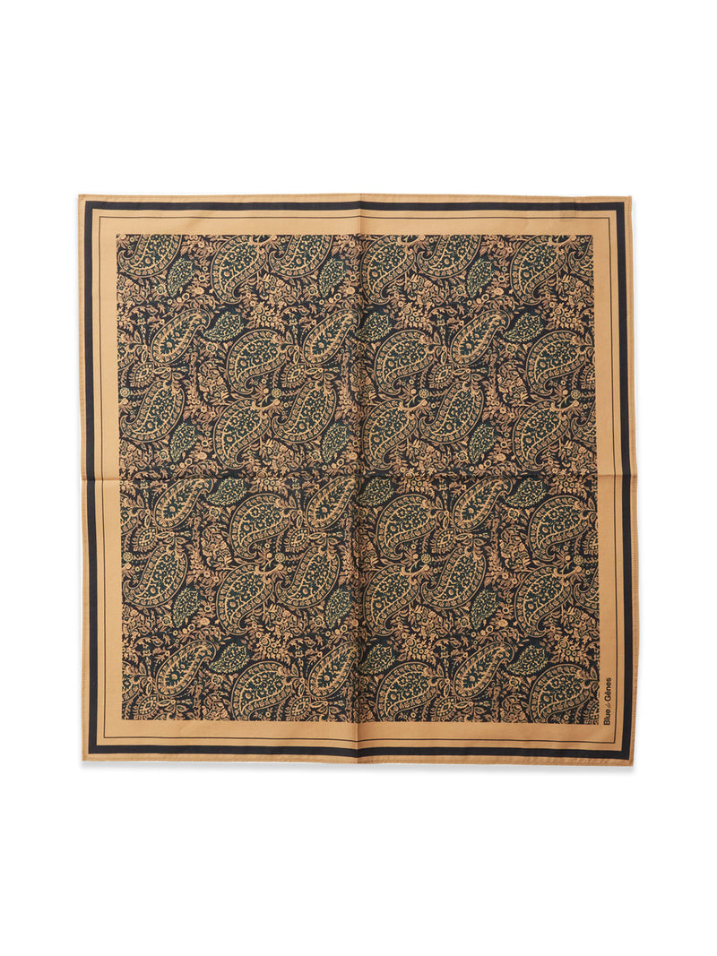 The Siruku Scarf - Mixed Colours by Blue de Gênes is a square cotton scarf with a detailed paisley and floral pattern in dark green, tan, and black, framed by tan and black borders. It’s displayed neatly with slight creasing.