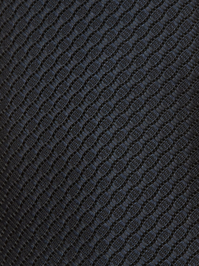 Close-up of the Nekutaki Tie #A - Navy by Blue de Gênes, featuring a dark, textured fabric with a raised diamond pattern that adds depth and subtle shine—ideal for a classic mens accessory.