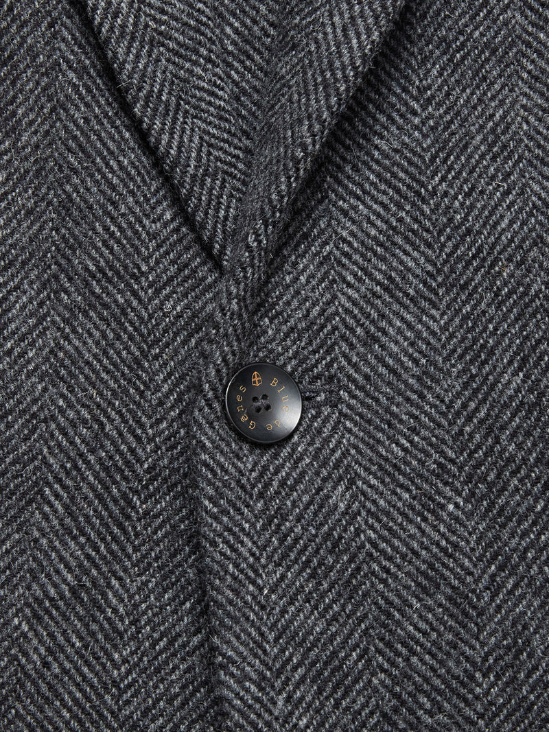 Close-up of the Blue de Gênes Fukui Blazer - Black Pattern, highlighting its refined herringbone fabric, a single black button with gold detail, and a defined notch lapel—a sophisticated spin on relaxed tailoring.