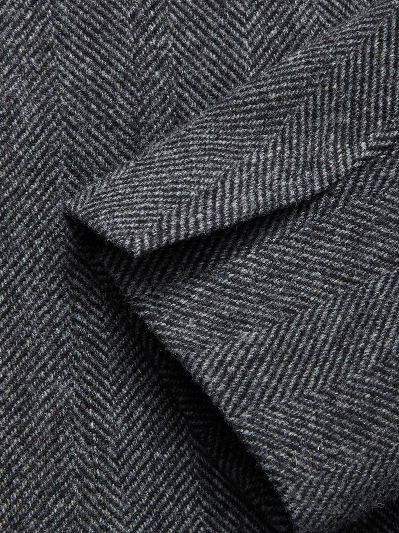 Close-up of the Fukui Blazer - Black Pattern by Blue de Gênes, highlighting grey herringbone fabric with overlapping sections and fine diagonal lines—a mark of contemporary tailoring.