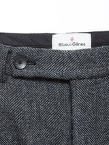 Close-up of the waistband of Kyoto Pant - Black Pattern by Blue de Gênes, showing a black button and a white Blue de Gênes label. These relaxed straight-leg trousers offer timeless style and comfort.