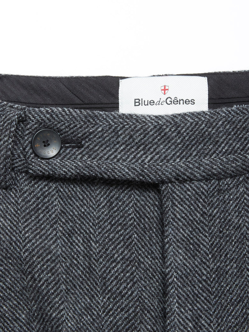 Close-up of the waistband of Kyoto Pant - Black Pattern by Blue de Gênes, showing a black button and a white Blue de Gênes label. These relaxed straight-leg trousers offer timeless style and comfort.